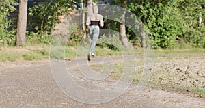 Close up of female legs running on field road outdoors at dawn in summer, concept of healthy running and outdoor