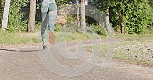 Close up of female legs running on field road outdoors at dawn in summer, concept of healthy running and outdoor
