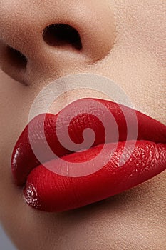 Close-up of female lips with bright makeup. Macro of woman`s face. Fashion lip make-up with red lipgloss