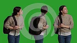 Close up of female model carrying backpack over greenscreen backdrop