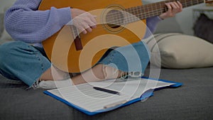 Close-up of female musician composing song and writing notes in music book