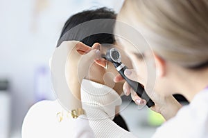 Close-up of female otolaryngologist examining ear with