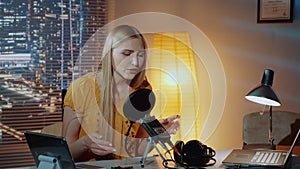 Close-up of female poet reading her poem into the microphone in home recording studio