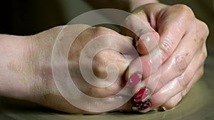 Close up of female potter hands working on pottery wheel.