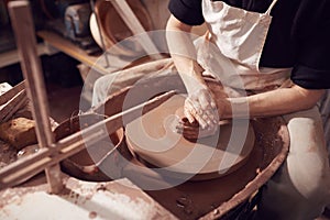 Close Up Of Female Potter Shaping Clay For Pot On Pottery Wheel In Ceramics Studio