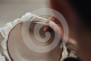 Close Up of Female Pottery Artist at Work, Woman Creating Patterns on a Clay Plate, Art Work in Process