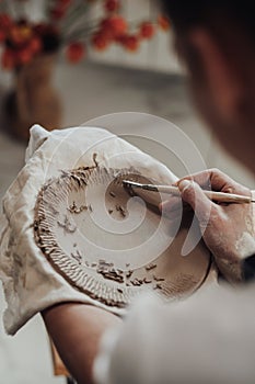 Close Up of Female Pottery Artist at Work, Woman Creating Patterns on a Clay Plate, Art Work in Process