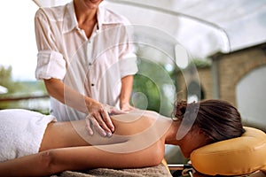 Close up of female receiving back massage at salon spa