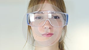 Close up of female reseach scientist, doctor in protective glasses