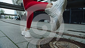Close up female runner legs jogging on urban street. Sporty girl training run.