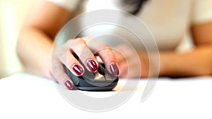 Close up of female's hand holding computer mouse, young business woman using computer in her office