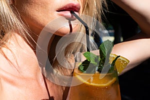 Close up of female sensual lips and mouth drinking lemonade cocktails. Cocktail menu. Party and summer. Fruit cocktail