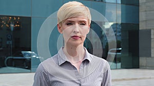 Close-up female serious face portrait caucasian middle aged business woman boss blonde short haired leader wears formal