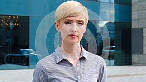 Close-up female serious face portrait caucasian middle aged business woman boss blonde short haired leader wears formal