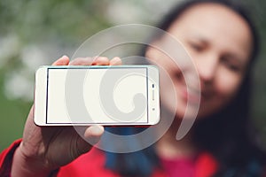 Close up of a female showing a blank horizontal phone screen on the street