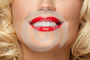 Close up female smile with white teeth and red lipstick makeup