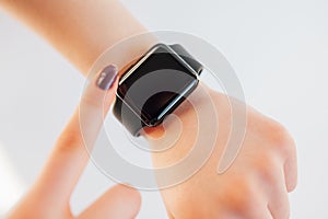 Close up female touching screen of smart wrist watch