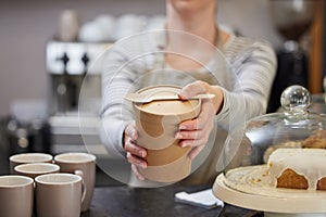 Close Up Of Female Worker in Cafe Serving Meal In Sustainable Recyclable Packaging With Wooden Spoon