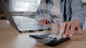 Close up female wrinkled hands of unknown mature woman housewife calculate numbers on calculator counting financial