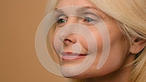 Close up female wrinkly smooth tighten face Caucasian mature senior 50s old woman touch perfect clean skin beauty anti