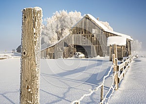 Close up of a fence post with wooden barn winter