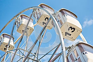 Close up ferris wheel against blue cloudy sky