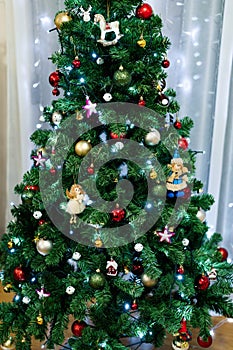 Close-up of a festively decorated Christmas tree with toys, balls and garlands.