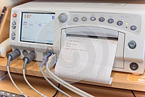 Close-up fetal monitor with baby heart beats at labor room hospital
