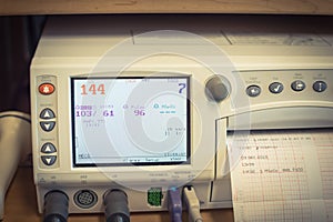 Close-up fetal monitor with baby heart beats at labor room hospital
