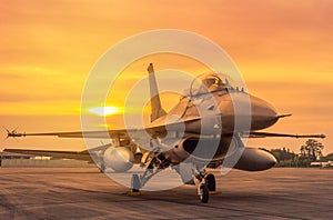 Close up fighter jet military aircraft parked on runway on sunset