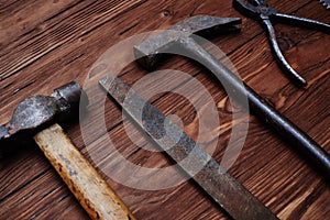 Close-up of file and a hammer isolated on wooden grunge background