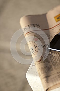 Close-up of financial newspaper and mobile phone