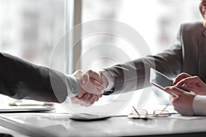 Close up. the financial partners shaking hands over a Desk