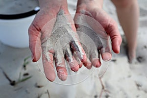 Close-up of fine sand in the palms pouring through the fingers