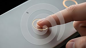 Finger Pressing Illuminated Button on Modern Device