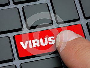 Close up finger pressing red virus key on computer keyboard