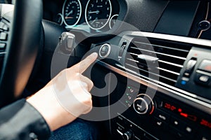 Close up of finger pressing the start stop engine button on car