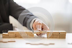 Close up of fingers assembling a bridge of blocks