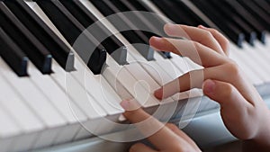 Close-up of fingers of a boy learning playing the piano. Creativity in children. Playing the pian