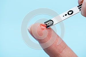 Close up of fingers and diabetes test strip isolated
