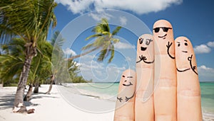 Close up of fingers with smiley faces on beach