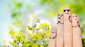 Close up of fingers with smiley faces over nature