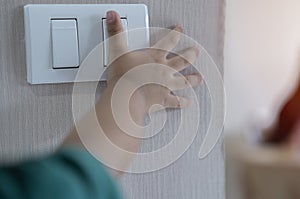 Close up fingerâ€™s kid is turning on or turning off the light-switch. Education about the economical use of resources