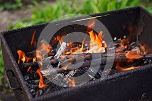 Close up of fire on chargrill. Dry sticks smoulder. Concept of cooking on grill