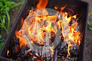 Close up of fire on chargrill. Dry sticks smoulder. Concept of cooking on grill