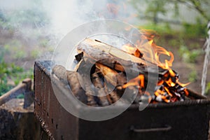 Close up of fire on chargrill. Dry sticks smoulder. Concept of cooking on grill