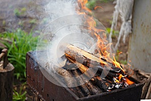 Close up of fire on chargrill. Dry sticks smoulder. Concept of cooking on grill