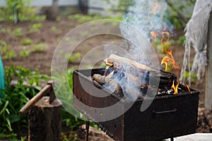 Close up of fire on chargrill. Dry sticks smoulder. Concept of cooking on grill