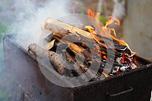 Close up of fire on chargrill. Dry sticks smoulder. Concept of cooking on grill