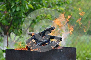 Close up of fire on chargrill. Dry sticks smoulder. Concept of cooking on grill